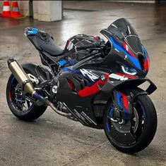 a red, black and blue motorcycle parked in a garage