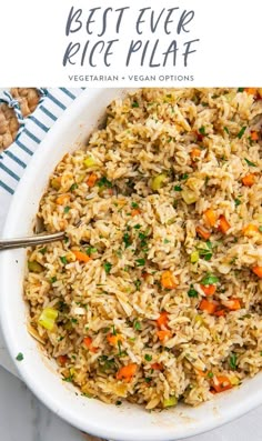 a bowl filled with rice and vegetables on top of a white table next to nuts