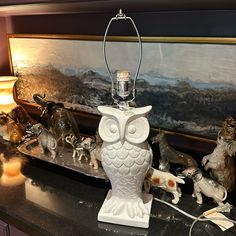 an owl lamp sitting on top of a counter next to other figurines