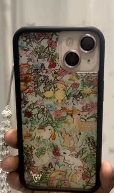 someone is holding up an iphone case with animals on it