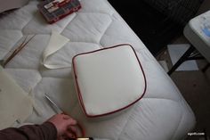 a person is cutting paper on top of a mattress