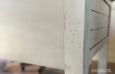 a close up view of the bottom of a white bed frame with wood slats