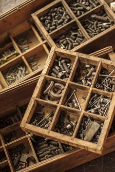 an open wooden box filled with lots of screws and nuts on top of a table