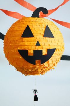 a paper pumpkin hanging from a string