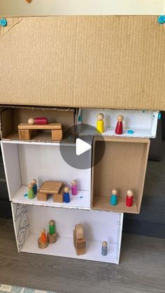 an open cardboard box sitting on top of a shelf filled with wooden blocks and toys