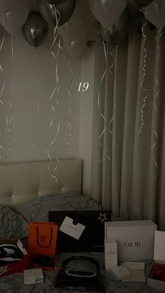 balloons are hanging from the ceiling above a bed