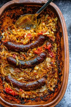 sausages and sauerkraut in a casserole dish with a spoon