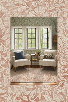 two chairs and a table in front of a window with floral wallpaper on the walls