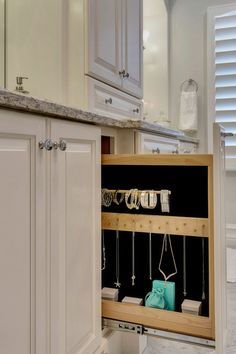 an open cabinet in a kitchen filled with jewelry