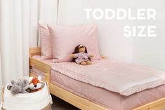 a toddler size bed with pink sheets and two stuffed animals on the bottom shelf