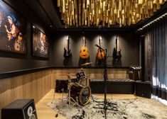 a recording room with guitars and other musical instruments on the wall, along with sound equipment