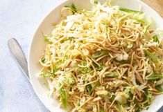 a white bowl filled with noodles and veggies