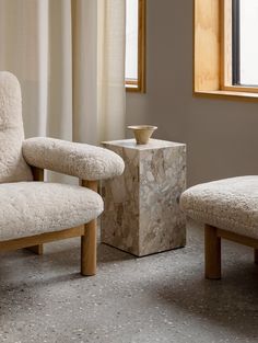 a chair and footstool in front of a window