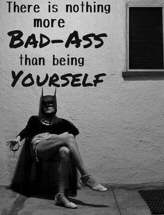 a woman sitting on top of a chair in front of a wall with a batman quote