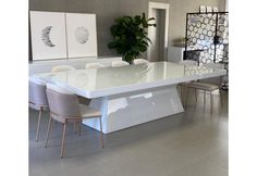 a large white table with chairs around it in the middle of a living room area