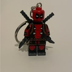 a lego deadpool character keychain with two swords in it's hands