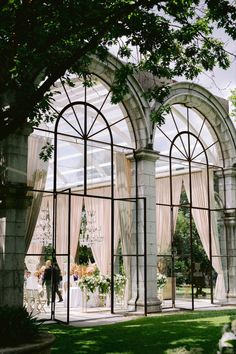 an outdoor wedding venue with large arched windows