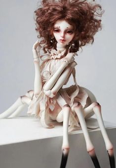 a doll sitting on top of a white table