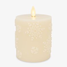 a lit candle with snowflakes on it