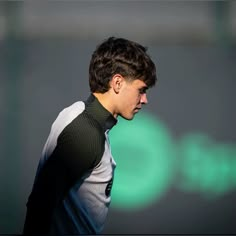 a young man holding a tennis racquet on top of a tennis court