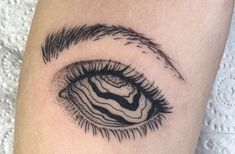 a close up view of an eye tattoo on the left thigh, with black and white lines