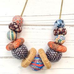 an assortment of colorful bead necklaces sitting on top of a white wooden table