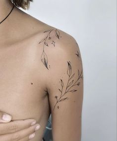 a woman's shoulder with leaves on it and a tattoo design on the chest