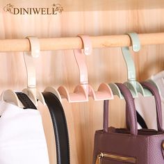 three purses are hanging on a wooden rack