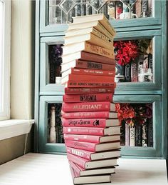 a stack of books sitting on top of each other in front of a book case