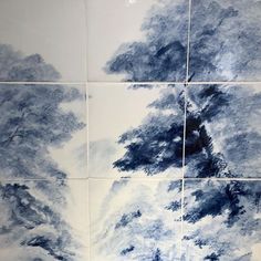 four blue and white tiles with trees painted on them