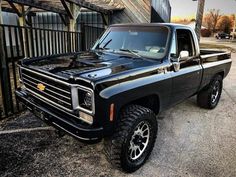 a black truck parked in front of a building