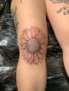 two women with tattoos on their legs and one has a sunflower tattoo