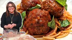 a woman standing next to a plate of spaghetti and meatballs