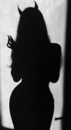 the shadow of a woman's head on a wall