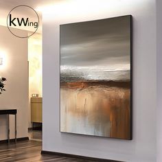 an abstract painting hangs on the wall next to a table and chair in a living room