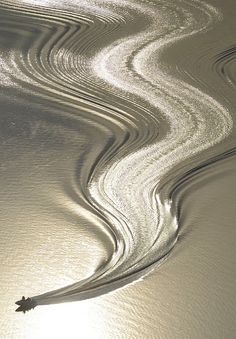 the sun shines brightly through wavy lines in the water, making it appear like waves