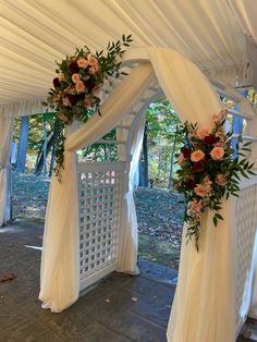 the wedding arch is decorated with flowers and greenery