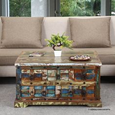 a coffee table made out of old doors and drawers with a vase on the top