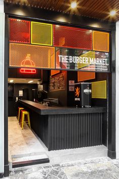 the burger market is located in an industrial building with neon lights on the front door