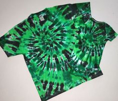 a green and black tie - dyed shirt sitting on top of a white countertop