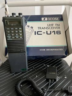 an icom transceiverr is sitting on top of a table next to a charger