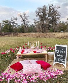 a picnic table is set up with pink flowers and candles for the guests to enjoy