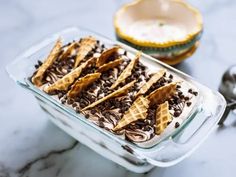 a glass dish filled with chocolate and waffles on top of a marble counter