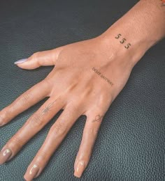 a woman's hand with tattoos on it and the word love written in cursive writing