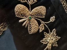 a black velvet table cloth with gold embroidered flowers on it