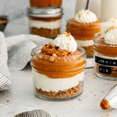 three jars filled with dessert sitting on top of a table