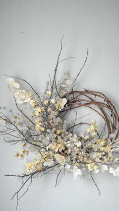 an arrangement of dried flowers on a white wall