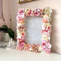 a white table topped with a mirror and flowers