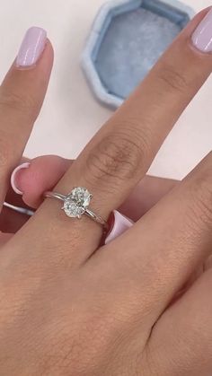 a woman's hand with pink manicured nails and a ring on her finger