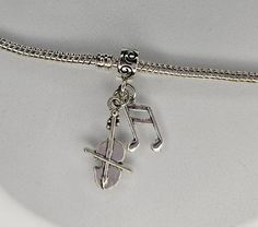 a silver charm with musical notes on it